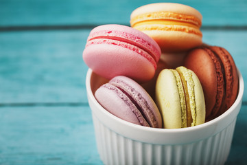 Macaroni cookies are placed in a white plate on a blue wooden background.