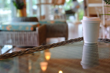 take away cup for hot coffee drink put on glass table in cafe shop