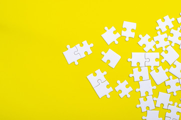 White jigsaw puzzle on a yellow background