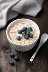 oatmeal with blueberries in a bowl on a wooden background. Top view.