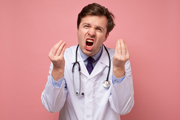 Caucasian man in medical white coat is showing italian gesture that means what do you want