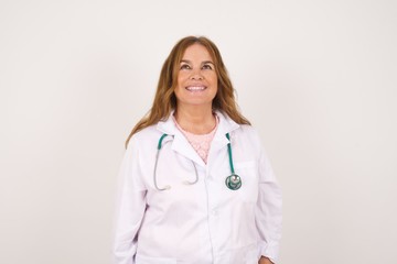 Fototapeta premium Horizontal portrait of pleasant-looking Caucasian doctor female wearing medical uniform covering her face with hair looking happily to the camera.