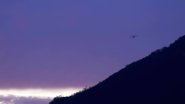 Lecco, Italy - March 2020: Firefighting aircraft Canadair flying in a cloudy sky at sunset during a fire emergency in the mountains near Lecco