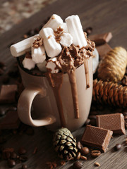 Hot chocolate and marshmallow in a brown cup, pine cones