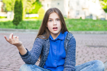 Happy girl smiling outdoor. Beautiful young brunete woman with brown hair resting on park or garden...