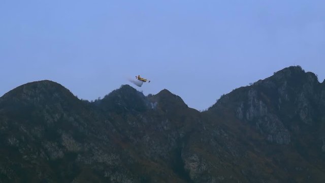Lecco, Italy - March 2020: Firefighting aircraft Canadair in action on a wildfire in the mountains near Lecco