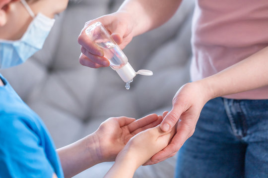 Family In Face Mask In Hand Sanitizer In Public Crowded Place During Coronavirus