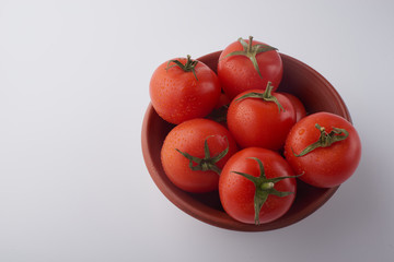 Close-up of fresh ripe tomatoes on a wooden and white background