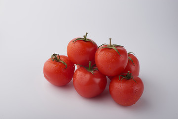 Close-up of fresh ripe tomatoes on a wooden and white background
