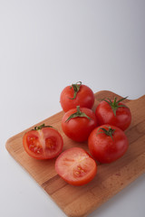 Close-up of fresh ripe tomatoes on a wooden and white background