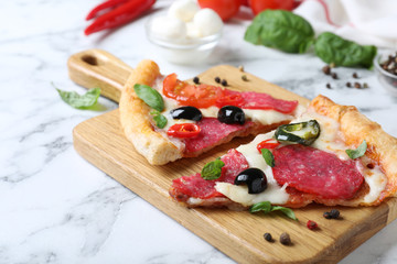 Composition with pieces of delicious pizza Diablo and ingredients on white marble table, closeup