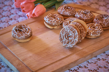 Obraz na płótnie Canvas Sweet biscuit with caramel on wooden board with flowers