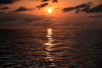 Panorama of beautiful sunset and evening clouds over the calm ocean. 