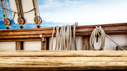 Wooden desk of free space for your decoration and blurred ship deck.Summer sea and blue sky. 