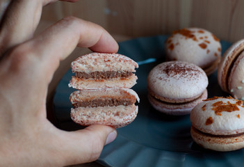 Hand holds two halves of chocolat macaron