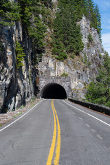 Straight road leading to a dark tunnel at Mount Rainier National Park in Washington, USA