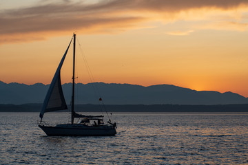 Small sailboat at sunset on the Puget Sound in Seattle, Washington, USA
