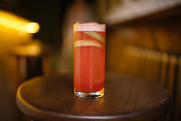 rhubarb sour cocktail in a highball glass on a wooden table