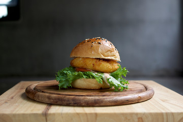 Tasty cheese burger on wooden table, Dark background. 
