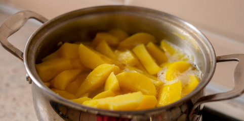raw fresh new yellow  potato being cooked in the saucepan with boiling water wide web banner