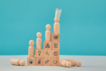 Leadership and winning. Teamwork, teambuilding. Goal achievement. Wooden pyramid with leader figure...