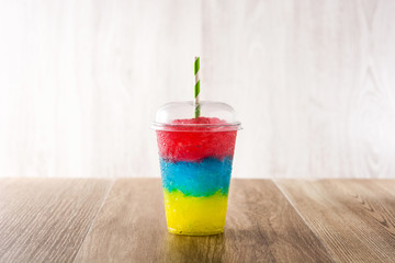 Colorful slushie with different flavors on wooden table