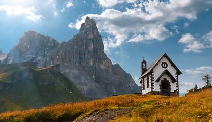 Summer mountain scenery in the Dolomites. Beautiful sunny landscape. The Dolomite Mountains and the small Christian church in the foreground