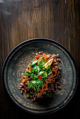 Fried rice with beef meat and vegetables in plate on wooden table background