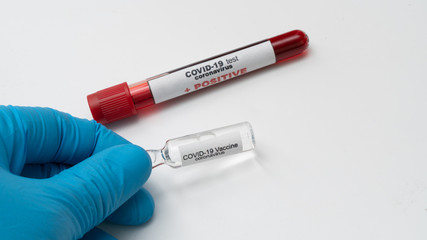 Doctor holds COVID 19 Coronavirus vaccine in his hand, infected blood sample in the sample tube, Vaccine and syringe injection It use for prevention, immunization and treatment from COVID-19