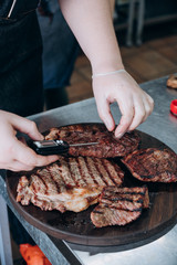 the cook checks the readiness temperature of juicy meat steaks