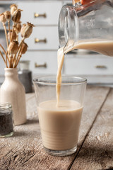 Pouring finished poppy seed milk into a glass