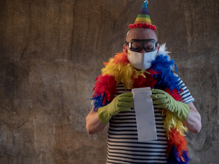 elderly man in colorful LGBT cape and hat protects himself from entering market. Blue mask, glasses, gloves, toilet paper in hands. pensioner learned to make an inexpensive mask of paper and tape