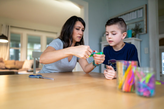 Mother showing children how to build a catapult out of popsicle sticks and rubberbands as part of a homeschool STEM lesson