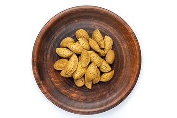 nuts almonds in the shell on a saucer on the white background