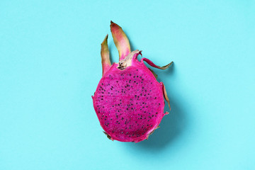 Pink pitahaya or dragon fruit on blue background. Top view. Copy space. Creative design banner....