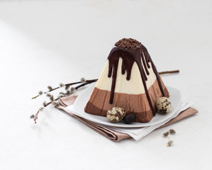 Festive Easter dessert of cottage cheese and three types of white, milk and bitter chocolate on a...