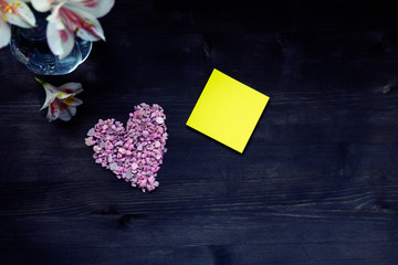Valentines day paper heart and flowers on brown wooden background.