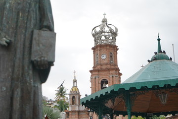 Fototapeta na wymiar Mirando el reloj en lo alto de la capilla en Puerto Vallarta