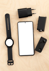 Smartphone and watch on a wooden table with a white screen. Smart Watch and Smartphone with a blank display.