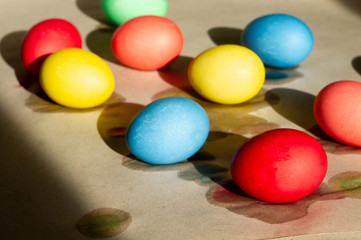 Fototapeta na wymiar Set of wet-paint homemade colorful Easter eggs on parchment paper. Spring holiday symbols. Christian gift.