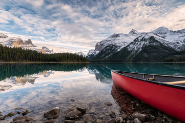 Red canoe parked on Maligne lake with Canadian rockies reflection in Spirit island at Jasper...