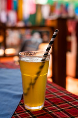 Glass of lemonade or fresh lime soda served with straw and placed on a table with colorful background, drink images for restaurant menus and advertisement