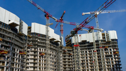 Construction site background. Cranes and new multi-story buildings.
