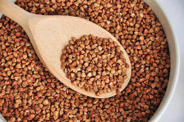 buckwheat on a plate and spoon isolated background