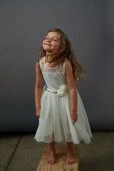 Naklejka premium A young girl on gray background makes a funny face