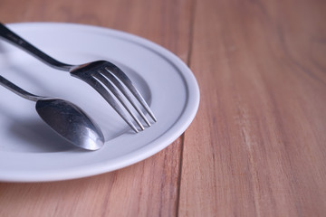 Close up of Empty plate, fork, spoon on table 