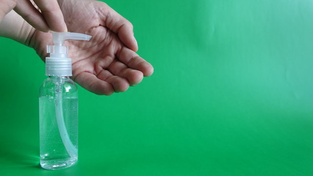 Applying Gel Into Left Hand From Pump Dispenser Against Green Screen Background - Powered by Adobe
