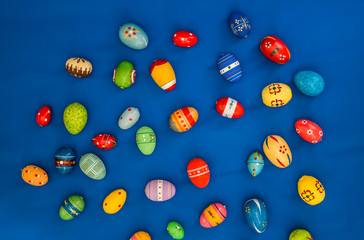 multicolored wooden eggs on blue background