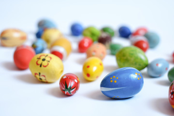 multicolored wooden eggs on white background