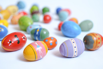 multicolored wooden eggs on white background
